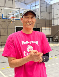 volleyball coach chijo with hat smiling in gym